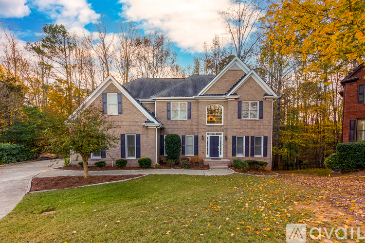 A house with a front yard and a tree with yellow leaves.