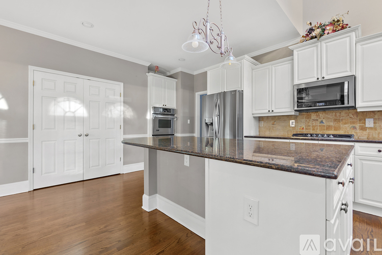 A kitchen with white cabinets and a granite countertop.