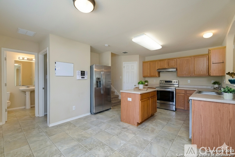 A kitchen with wooden cabinets and a tile floor.