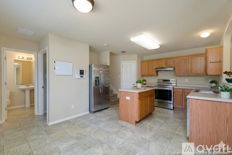 A kitchen with wooden cabinets and a tile floor.
