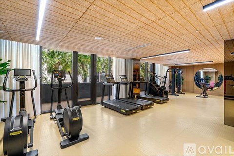 A gym with treadmills, elliptical machines, and other exercise equipment.