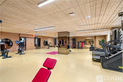 A gym with a variety of equipment including treadmills, weights, and exercise machines.