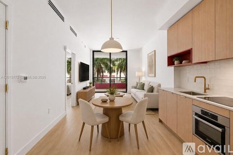 A modern kitchen with a dining table and chairs in the foreground.