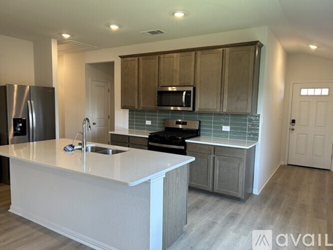 A kitchen with a white countertop and wooden cabinets.