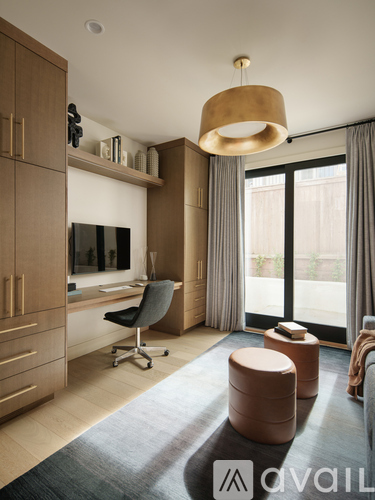 A modern living room with a television, a desk, and a chair.