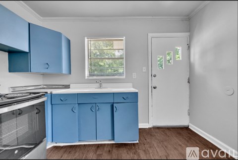A kitchen with blue cabinets and a white door.