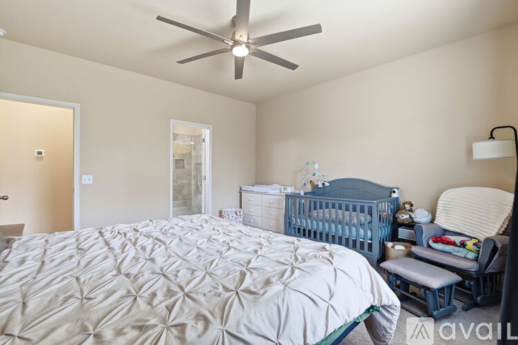 A bedroom with a large bed and a baby crib.