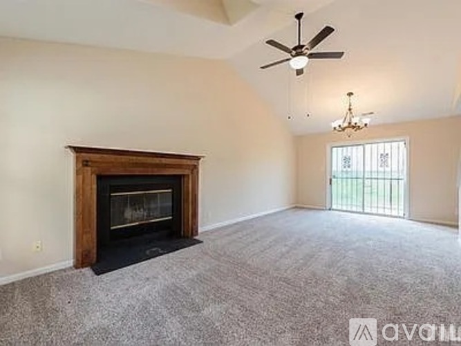 A living room with a fireplace and a ceiling fan.