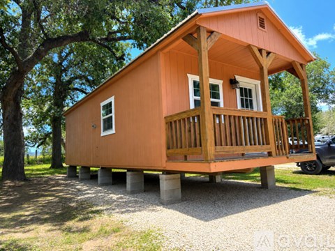 A small wooden cabin with a porch and a balcony.