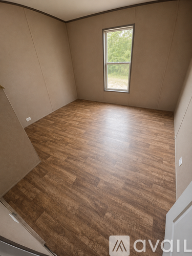 A room with wooden flooring and a window.