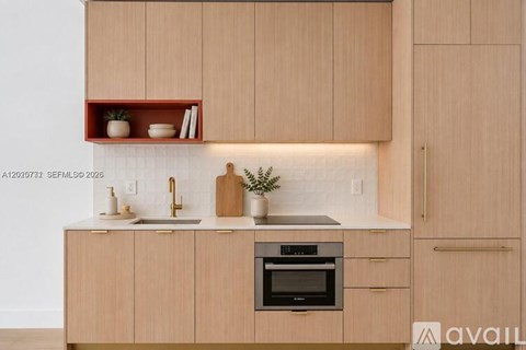 A modern kitchen with wooden cabinets and a built-in oven.