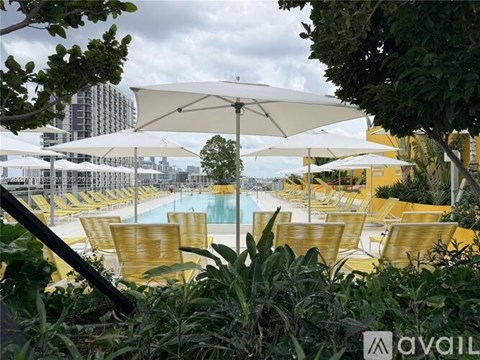 A pool area with sun loungers and umbrellas.