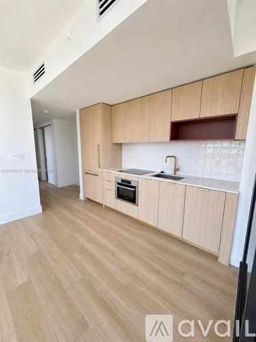 A kitchen with wooden floors and cabinets.