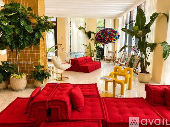 A living room with red couches and plants.