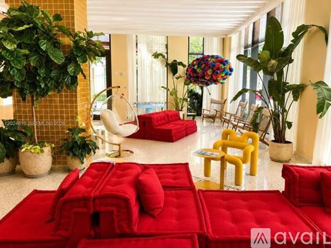 A living room with red couches and plants.