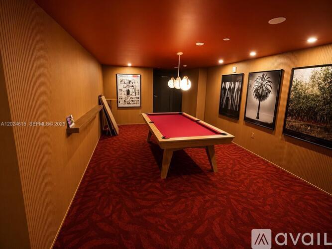 A room with a pool table and pictures on the wall.