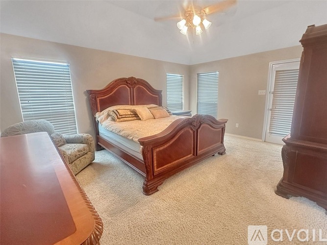 A bedroom with a large bed and a wooden headboard.