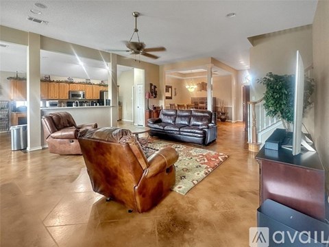 A living room with a brown leather couch and a rug.