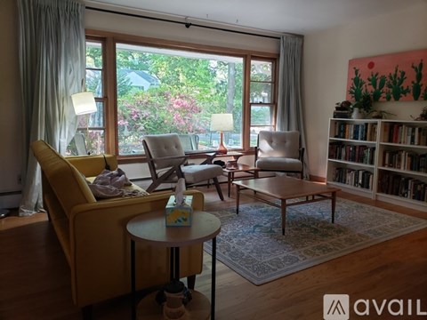 A living room with a yellow chair and a table with a box on it.