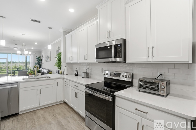 A modern kitchen with white cabinets and stainless steel appliances.