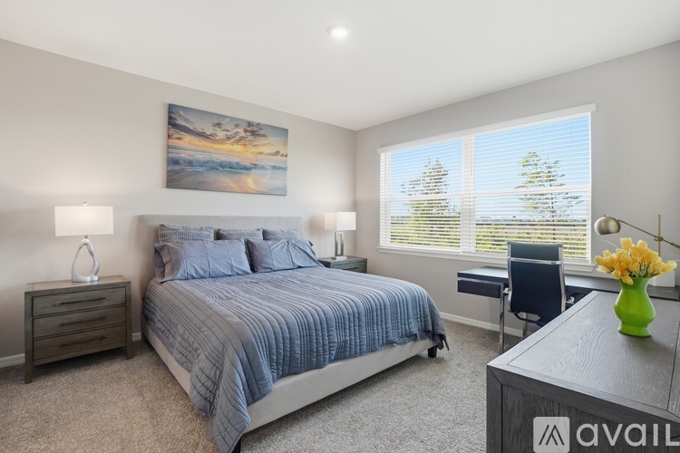 A bedroom with a large bed and a painting on the wall.