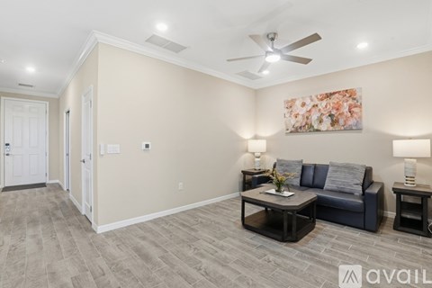 A living room with a grey sofa, a coffee table, and a painting on the wall.