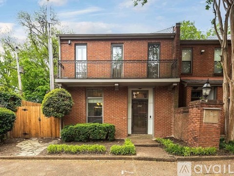 A brick house with a balcony and a door.