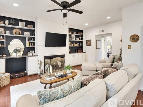 A living room with a white couch and a fireplace.