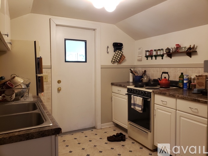 A kitchen with a white door and a black and white checkered floor.