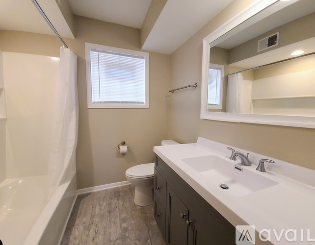 A bathroom with a white tub, sink, and toilet.