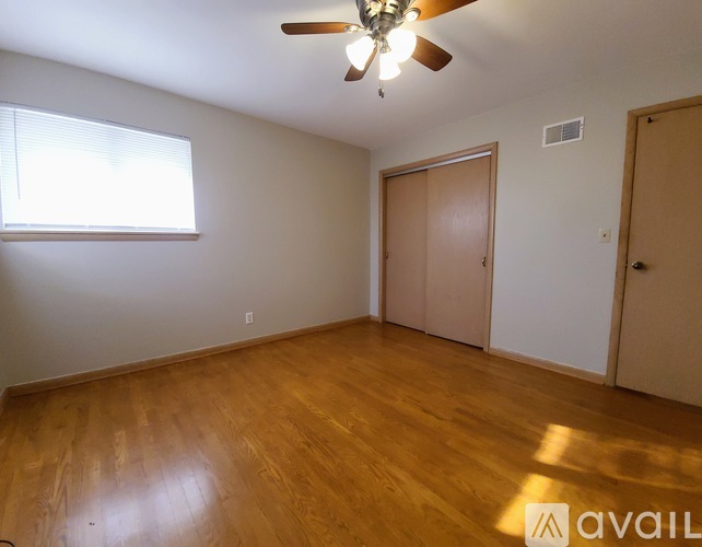 A room with wooden floors and a ceiling fan.