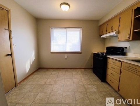 A kitchen with a black dishwasher and a black stove top oven.
