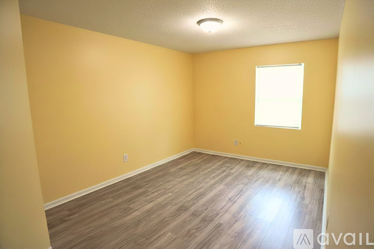 A room with a wooden floor and a window.