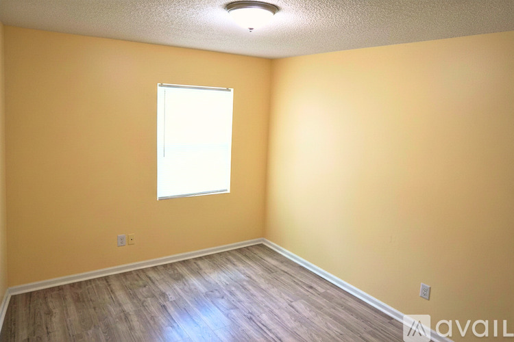 A room with a window and wooden flooring.