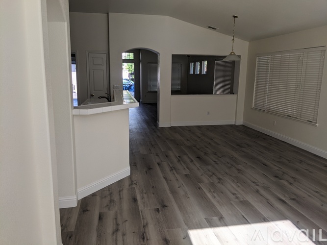 A room with wooden flooring and white walls.