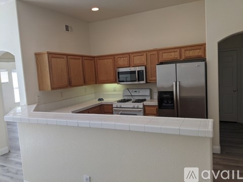 A kitchen with white countertops and wooden cabinets.
