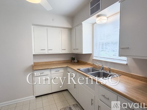 A kitchen with white cabinets and a wooden countertop.