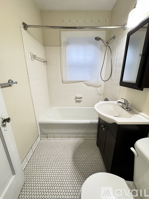 A white bathroom with a black and white tiled floor.