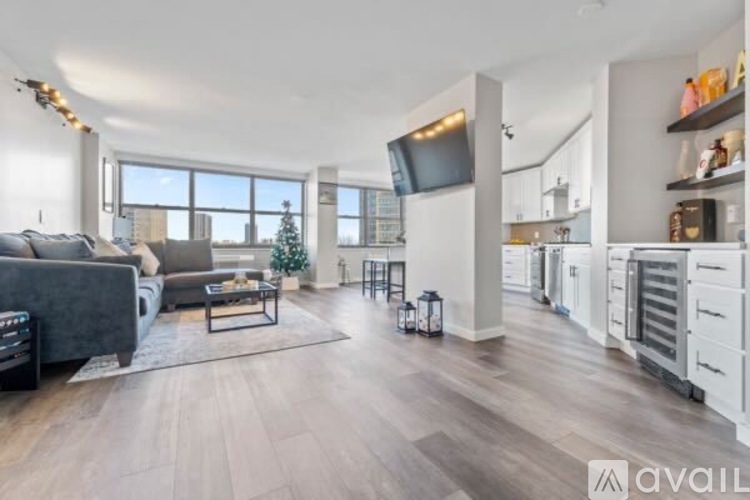A modern living room with a grey sofa and a wooden floor.
