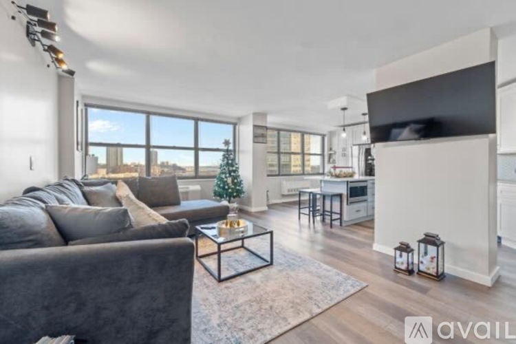 A living room with a grey couch and a coffee table in front of a large window.