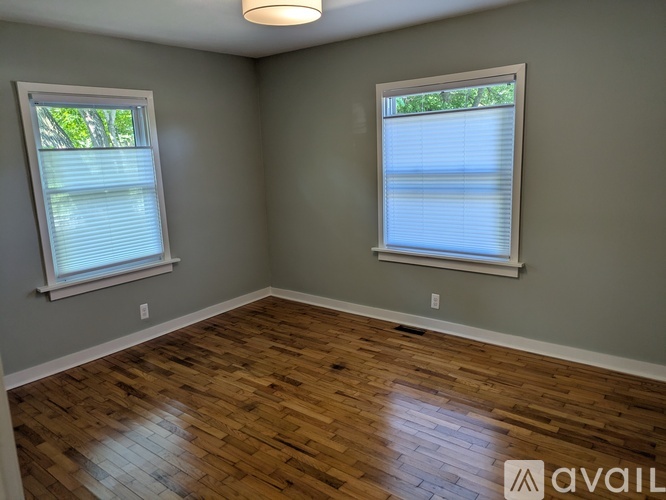 A room with wooden floors and two windows.