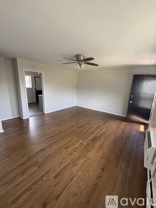 A room with wooden flooring and a ceiling fan.