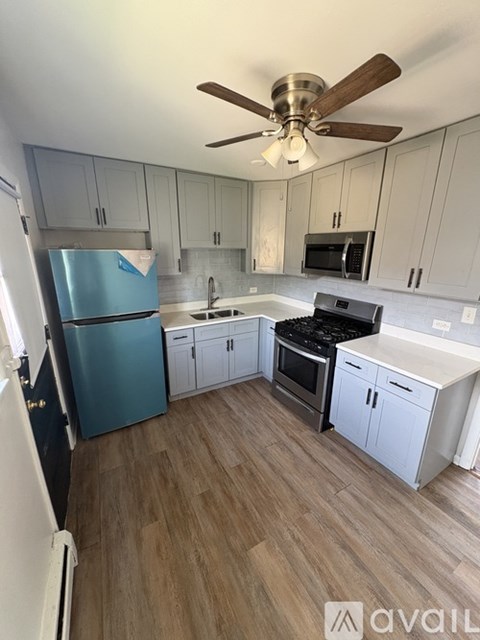 A kitchen with a blue refrigerator and wooden floors.