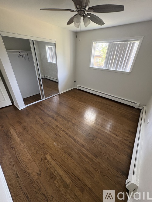 A room with wooden flooring and a ceiling fan.