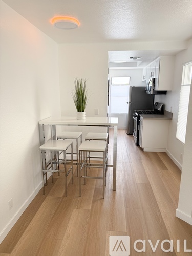 A kitchen area with a table and chairs.