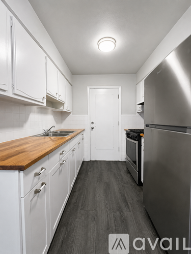 A kitchen with white cabinets and a wooden countertop.