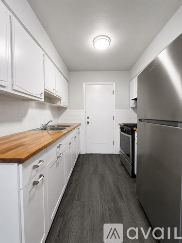 A kitchen with white cabinets and a wooden countertop.