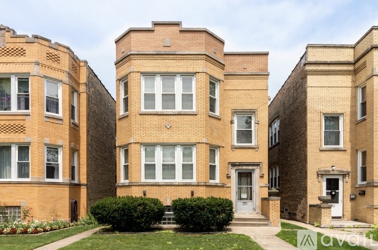A row of brown brick apartment buildings with white doors and windows.