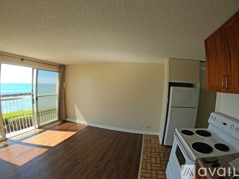 A kitchen with a stove and a view of the beach.