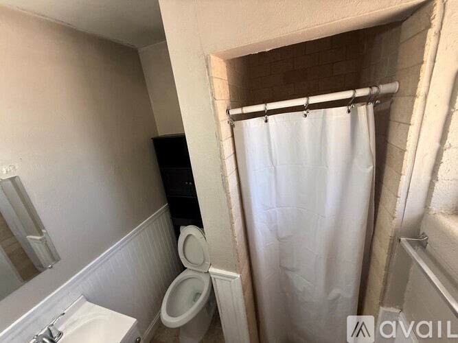 A bathroom with a toilet, sink, and shower.